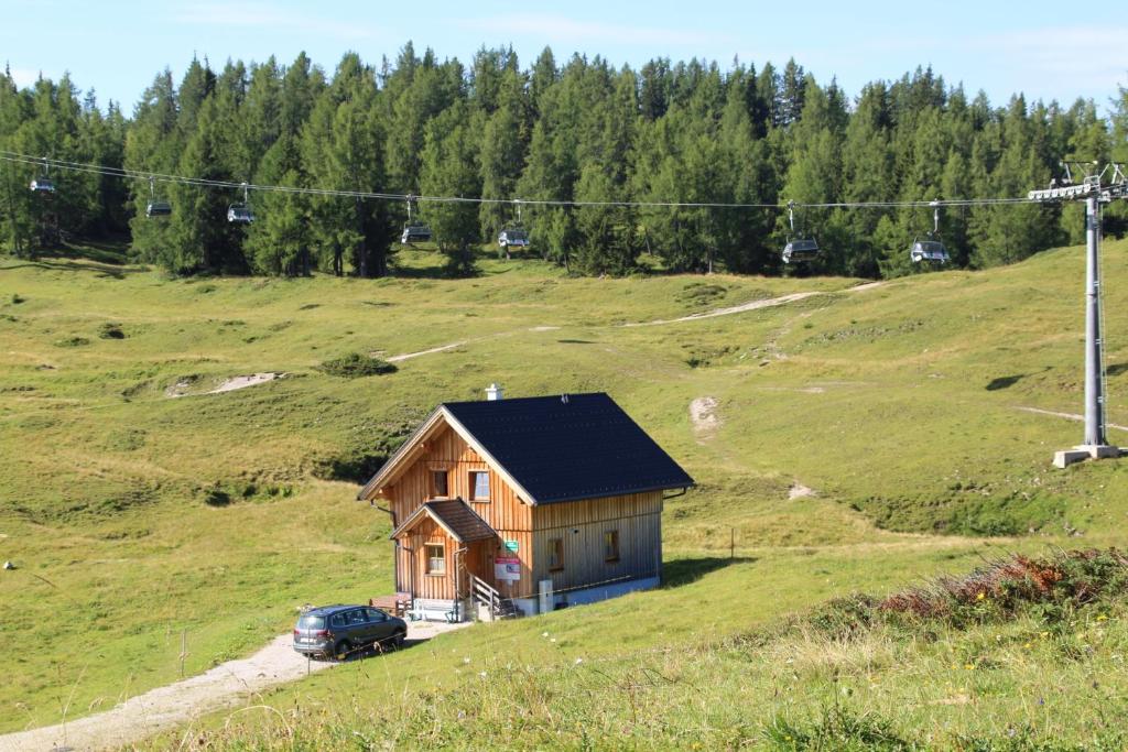 een klein huis op een heuvel in een veld bij kleine Winklerhütte in Tauplitz