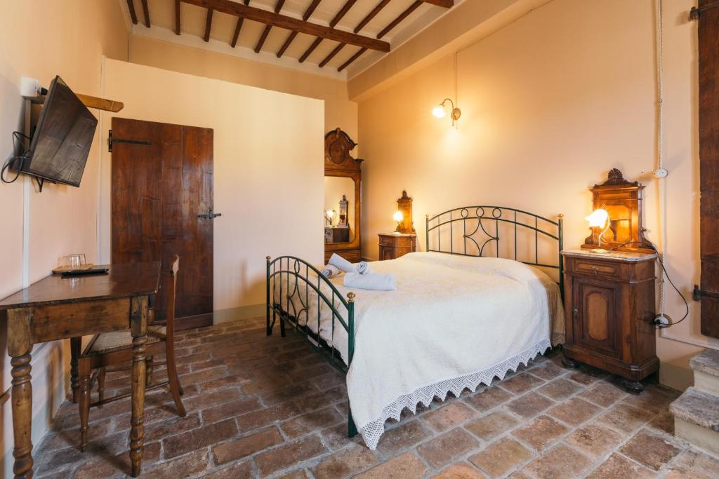 a bedroom with a bed and a table and a desk at A Palazzo in Pergola