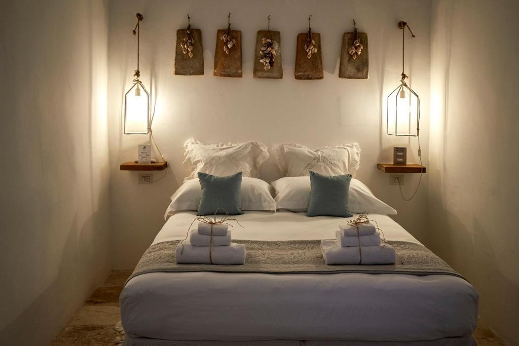 a bedroom with a large white bed with two pillows at Dei Serafini in Polignano a Mare