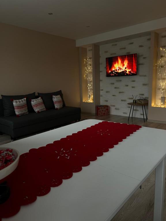 a living room with a bed with a red carpet at ESSE Apartament in Gulbene