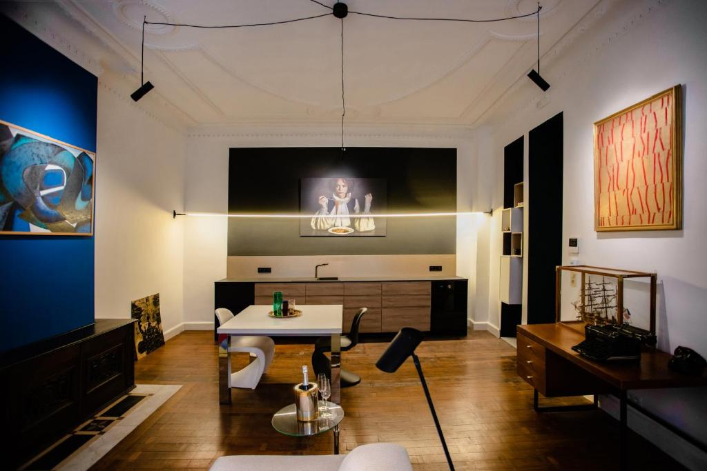 ein Wohnzimmer mit einem Tisch und einem TV an der Wand in der Unterkunft GITADIN - Deluxe Suite Valens - Historical Center in Lüttich