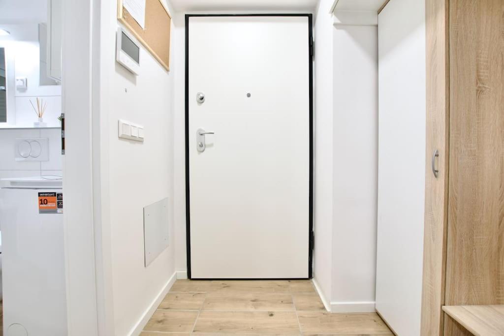 a white door in a kitchen with a wooden floor at Standard Apartment by Hi5-Horváth Mihály square in Budapest