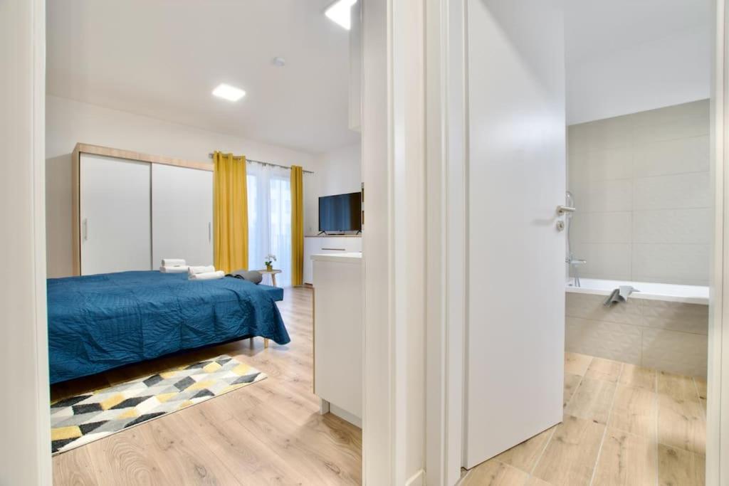 a bedroom with a blue bed and a bathroom at Standard Apartment by Hi5-Horváth Mihály square in Budapest