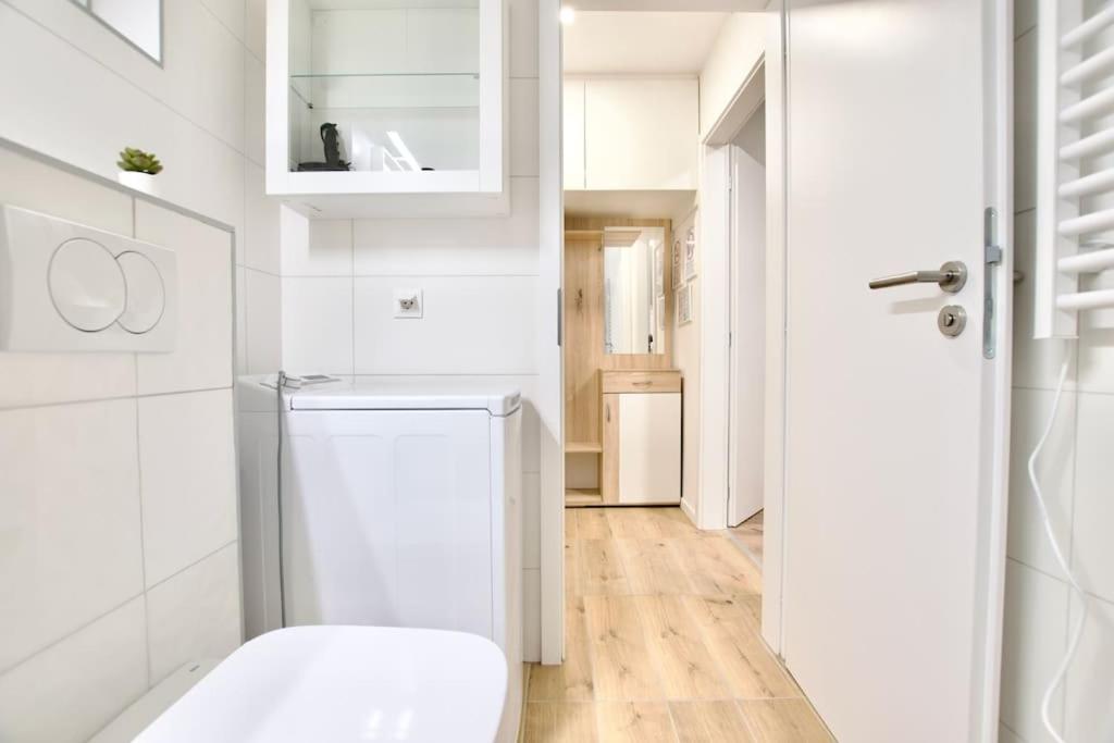 a white kitchen with a washer and dryer at Standard Apartment by Hi5-Horváth Mihály square in Budapest
