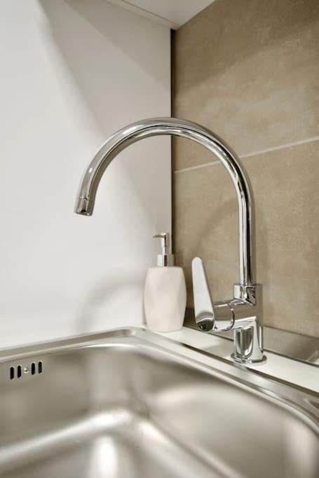 a kitchen sink with a faucet and a sink at Standard Apartment by Hi5-Horváth Mihály square in Budapest