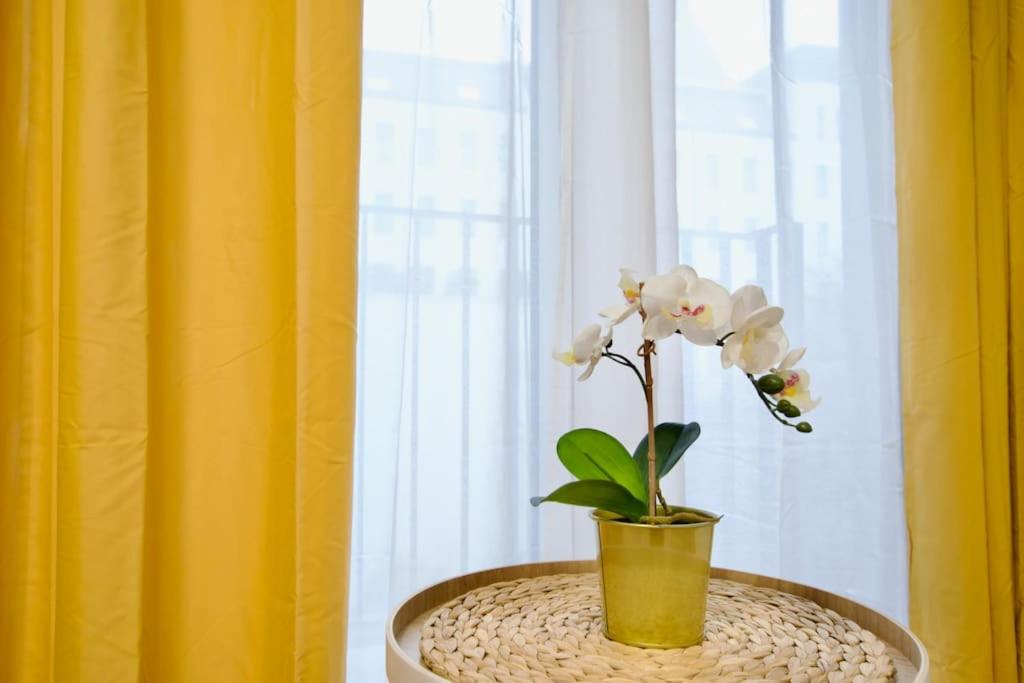 a yellow vase with a plant in it on a table at Standard Apartment by Hi5-Horváth Mihály square in Budapest