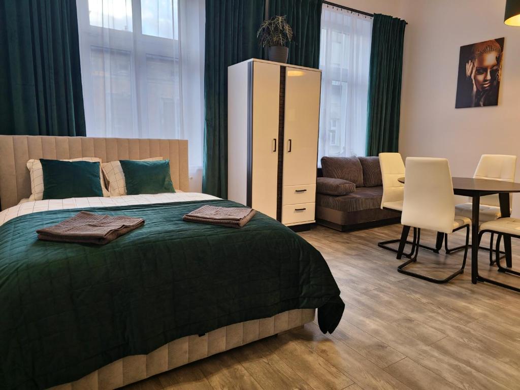 a bedroom with a bed and a dining room at Apartamenty Lenart in Krakow