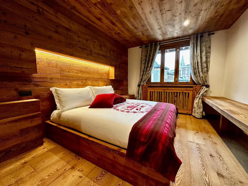 um quarto com uma cama num quarto de madeira em Alpine Escape 3 em Bormio