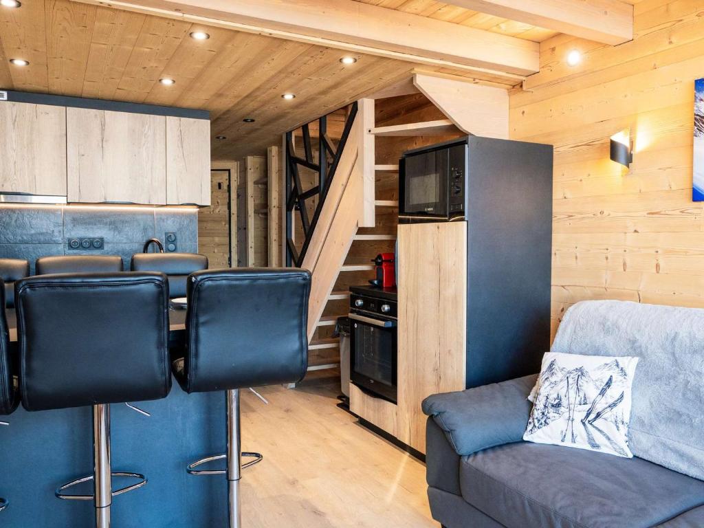 Una sala de estar con un sofá y una cocina. en Appartement montagne rénové, 6 pers, proche pistes et commodités - FR-1-637-59, en Val Thorens