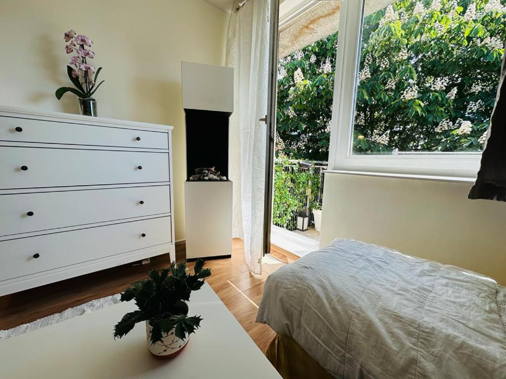 a bedroom with a bed and a dresser and a window at 300m od Rynku Sinus Apartaments in Wejherowo