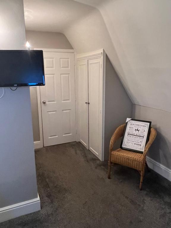 a room with a staircase with a chair and a sign at White horse in Empingham