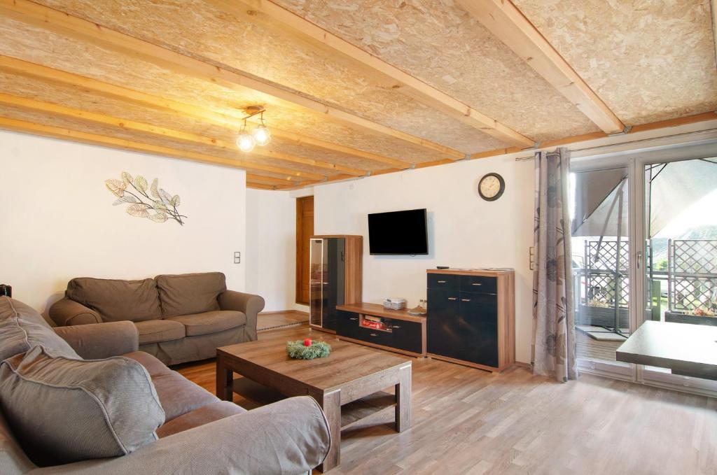 uma sala de estar com um sofá e uma televisão em Schönfeld em Stockach