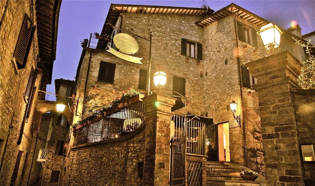 ein großes Steingebäude mit einer Uhr drauf in der Unterkunft La Locanda Del Capitano in Montone