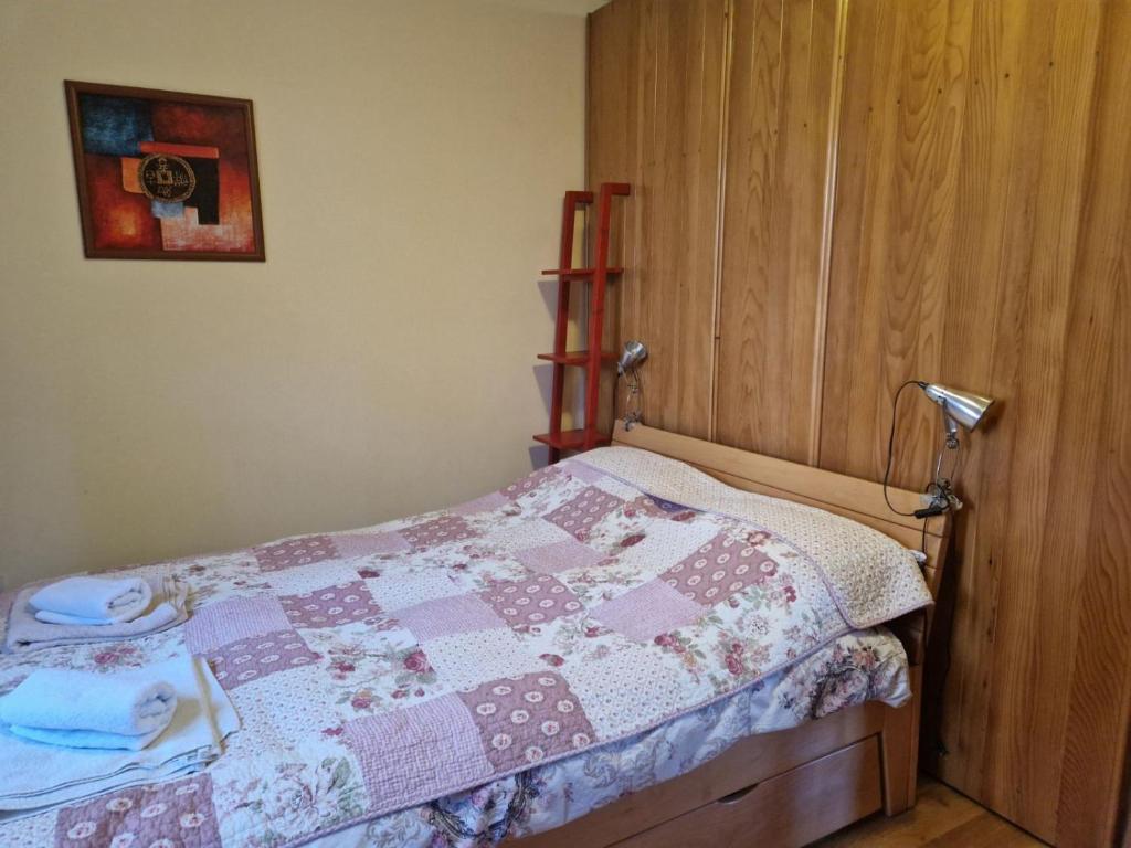 a bedroom with a bed with a quilt on it at Apartmani - Mesko vajat in Divčibare