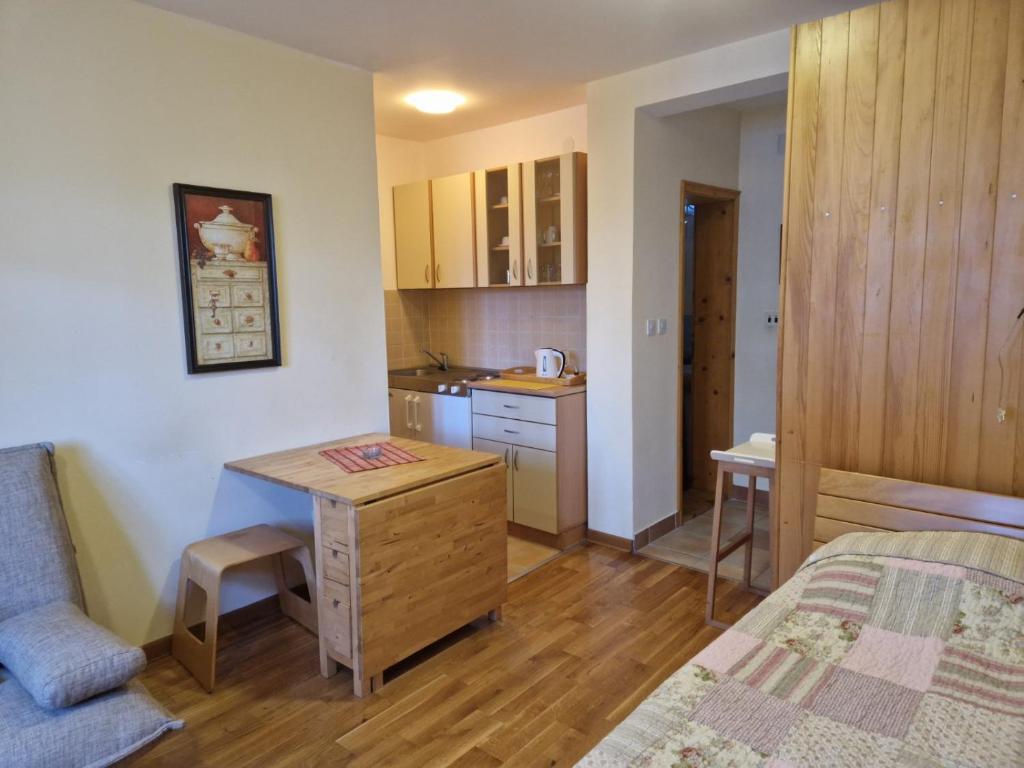 a small room with a desk and a kitchen at Apartmani - Mesko vajat in Divčibare