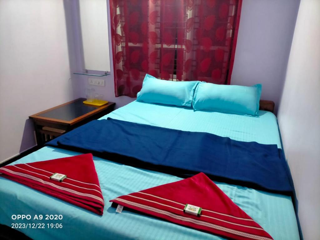 a bedroom with two beds with red pillows on them at Om home stay in Kumta