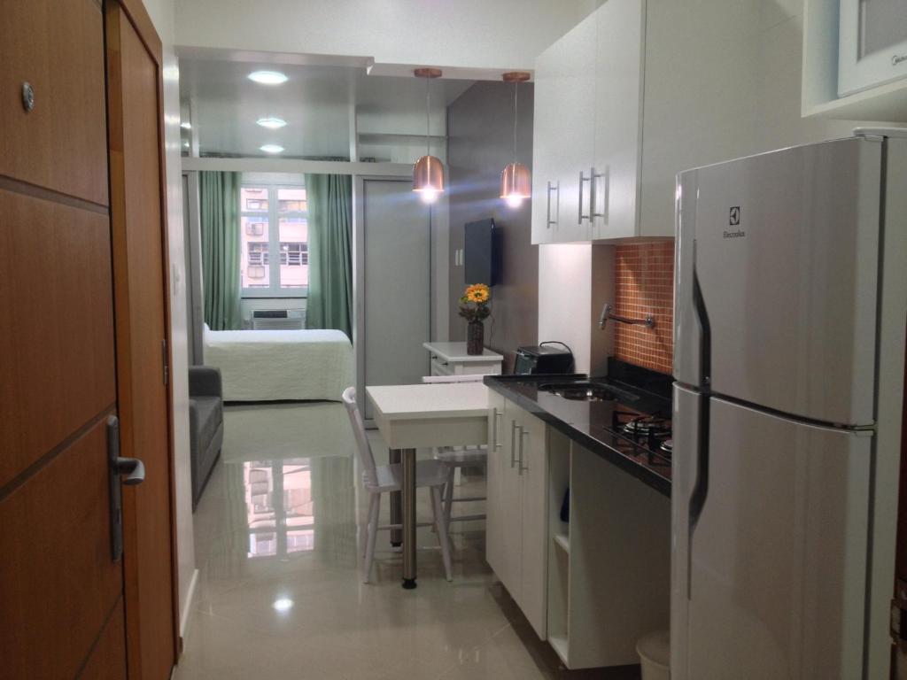 uma cozinha com um frigorífico branco e uma mesa em PJ160 no Rio de Janeiro