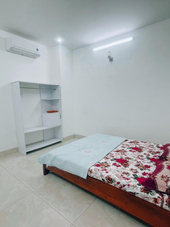 1 dormitorio con 1 cama en una habitación blanca en HOATEL MEKONG HOME GUESTHOUSE, en Can Tho