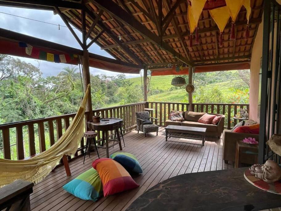 - une terrasse couverte avec un hamac sur une terrasse en bois dans l'établissement Casa Rosa Hospedaria, à Araxá