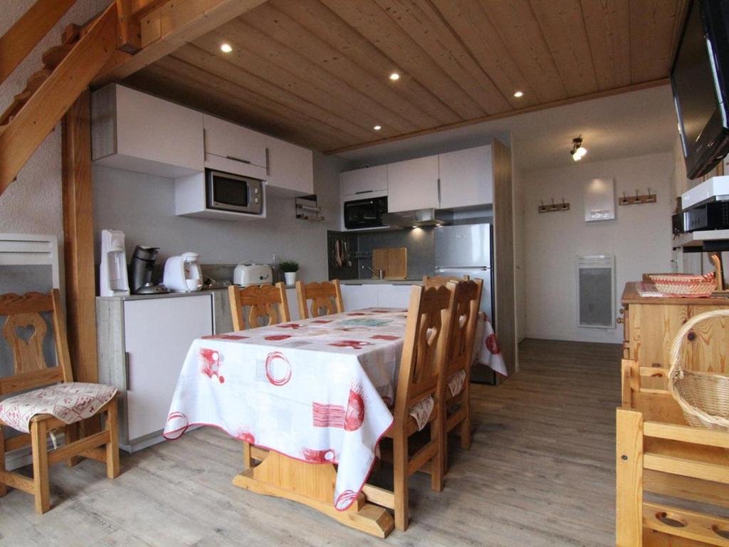 une cuisine et une salle à manger avec une table et des chaises dans l'établissement Charmant 4 pièces avec balcon, proche commerces et remontées, Alpe d'Huez, 6 pers, animaux acceptés - FR-1-405-133, à L'Alpe-d'Huez