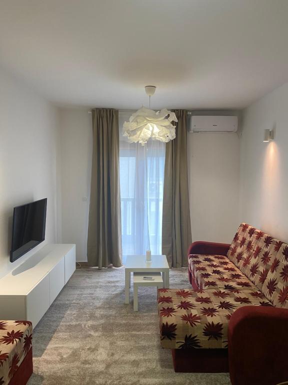 a living room with a couch and a tv at Apartment VaLi in Herceg-Novi