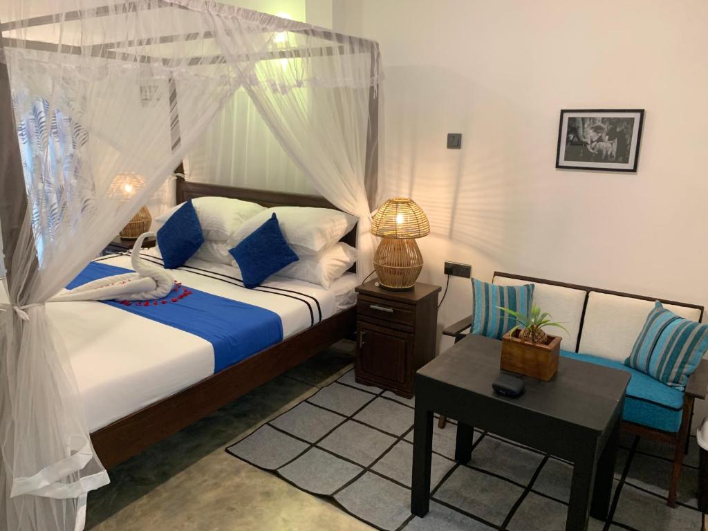 Habaraduwa Central的住宿－Samadhi Garden，一间卧室配有一张带天蓬和椅子的床