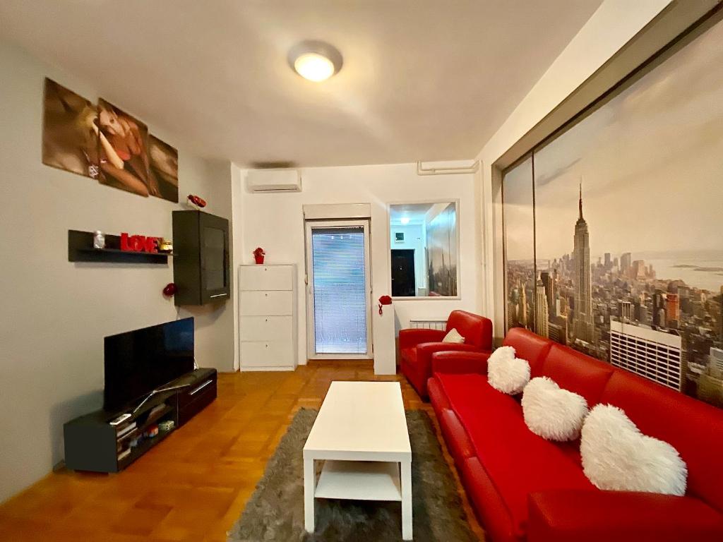 uma sala de estar com um sofá vermelho e uma mesa em Sunny em Belgrado
