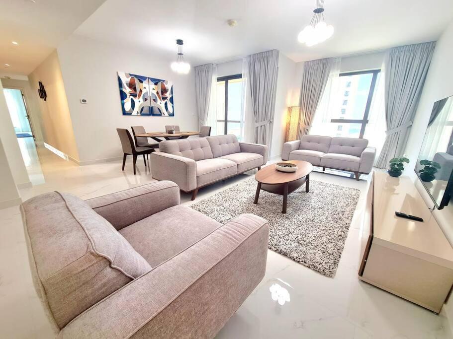 Nr to beach-Beautifully upgraded في دبي: غرفة معيشة مع كنبتين وطاولة