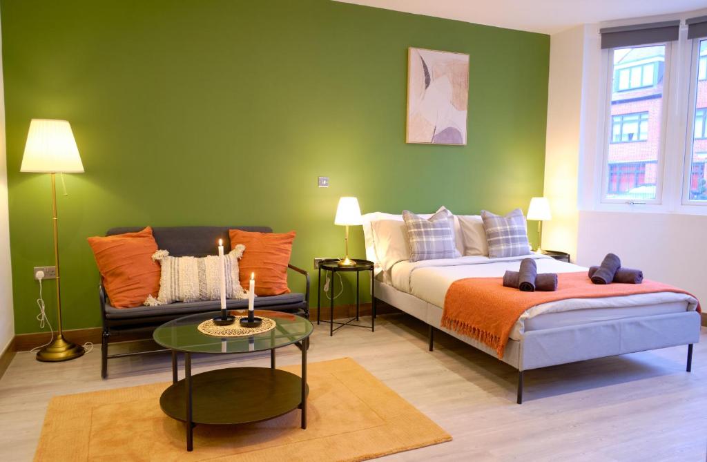 a bedroom with a bed and a couch and a table at GoldersGreen Apartments by Sleepy in London