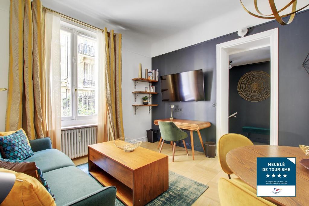 sala de estar con sofá y mesa en Séjours Parisiens / Suite Belle Courcelles / 4*, en París