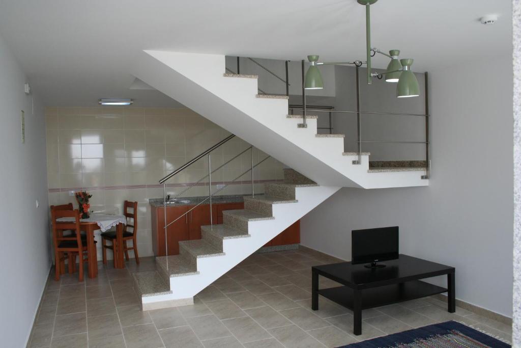 Casa Lagar do Miradoyro في كارامولو: درج في غرفة المعيشة مع طاولة