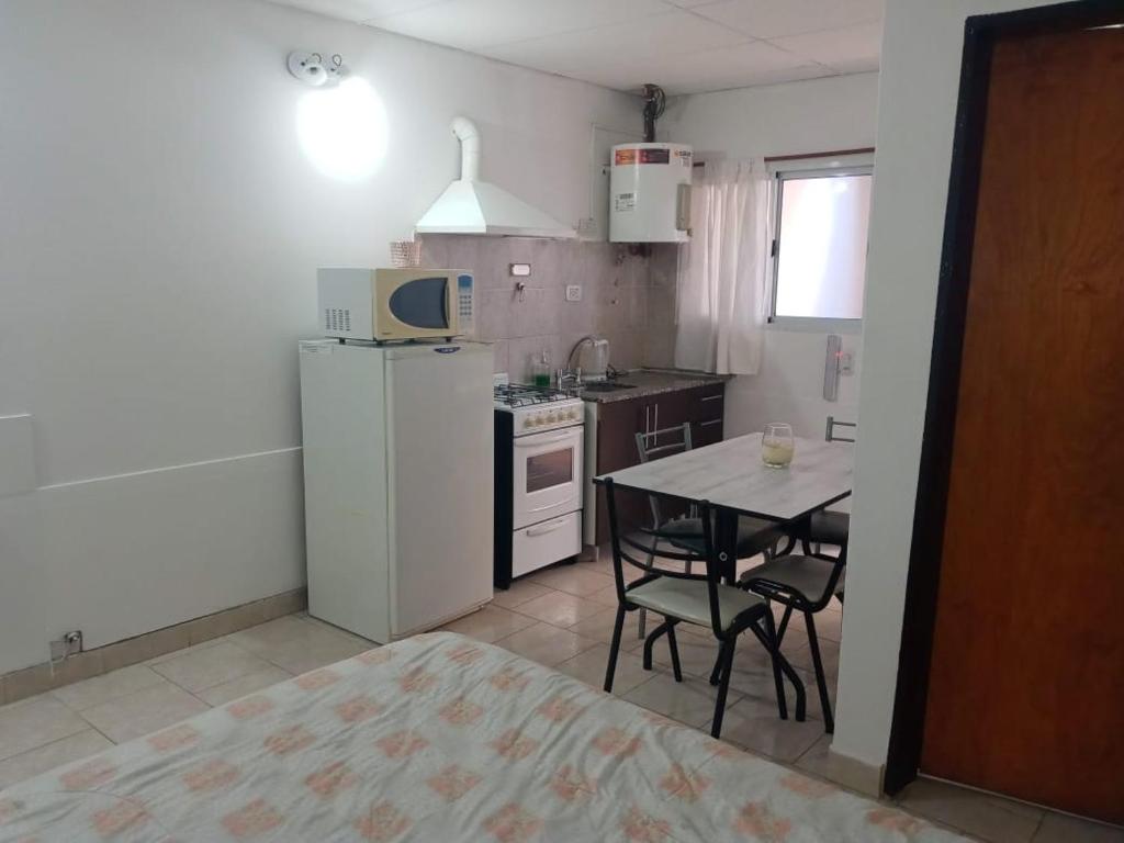 a small kitchen with a table and a white refrigerator at Gotas de Rocio in San Antonio Oeste