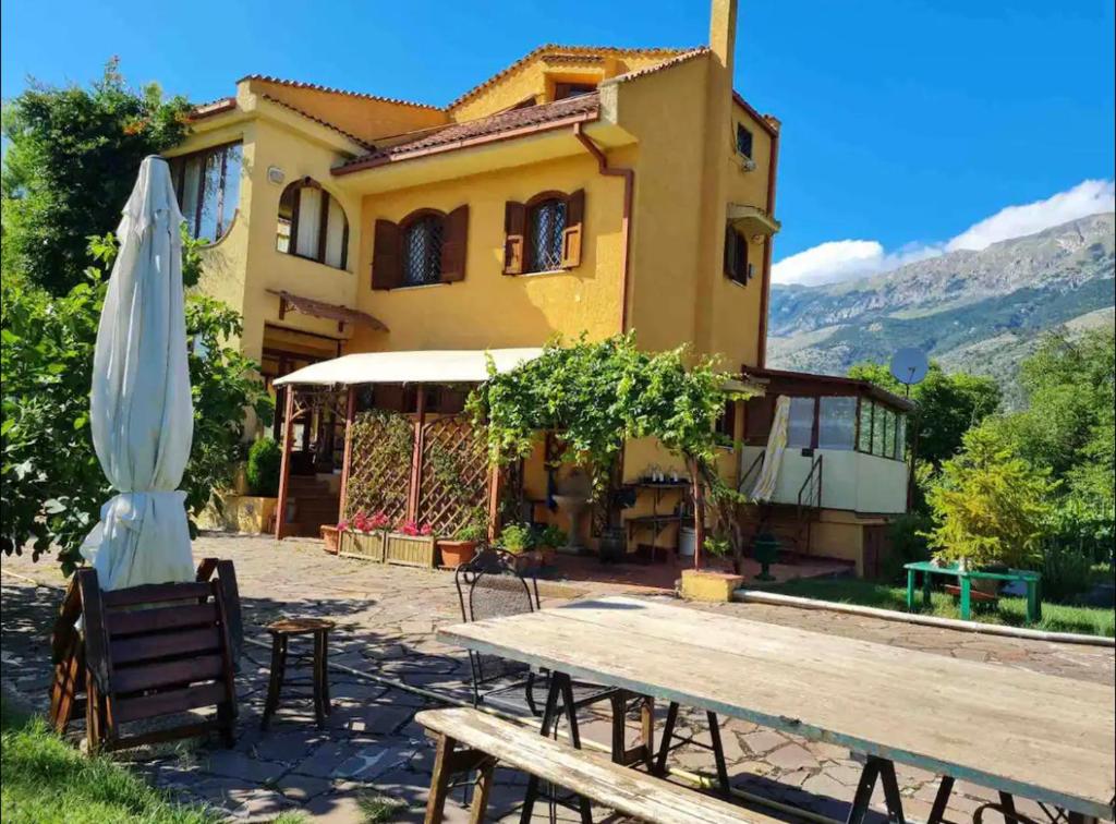 a table and umbrella in front of a house at Villa Alberto in Sulmona