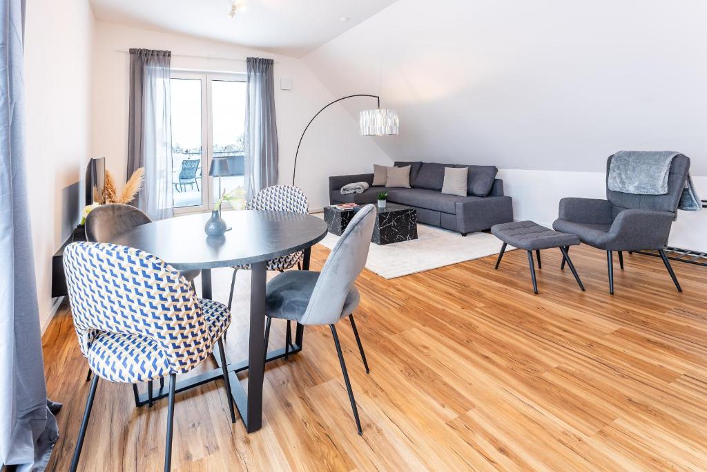 uma sala de estar com uma mesa e cadeiras e um sofá em Tonirooms Penthouse em Straubing