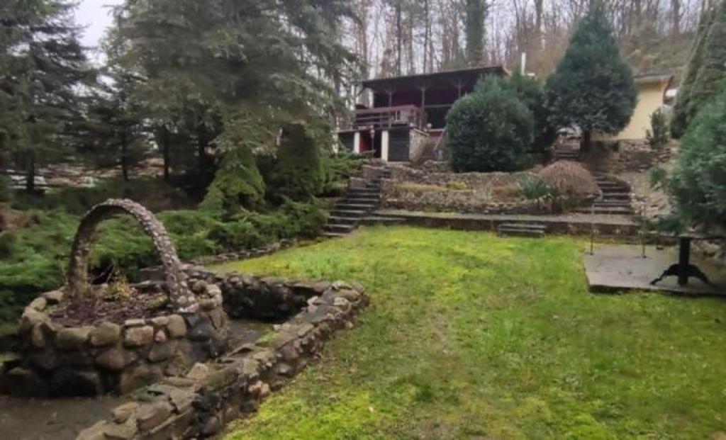 einen Garten mit einer Steinmauer und einem Haus in der Unterkunft Ferienhaus im Odertal in Stolpe