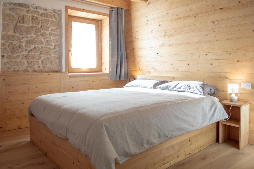 - une chambre avec un lit dans une pièce en bois dans l'établissement Begale - Rifugio Urbano, à Rotzo