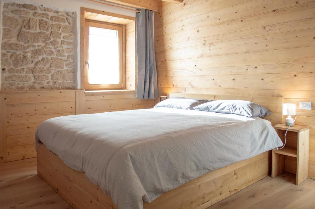 a bedroom with a bed in a wooden room at Begale - Rifugio Urbano in Rotzo