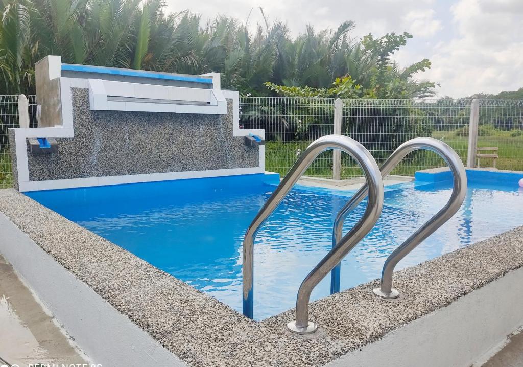 a swimming pool with two metal rails in the water at Afeeya The Roomstay in Kuala Terengganu