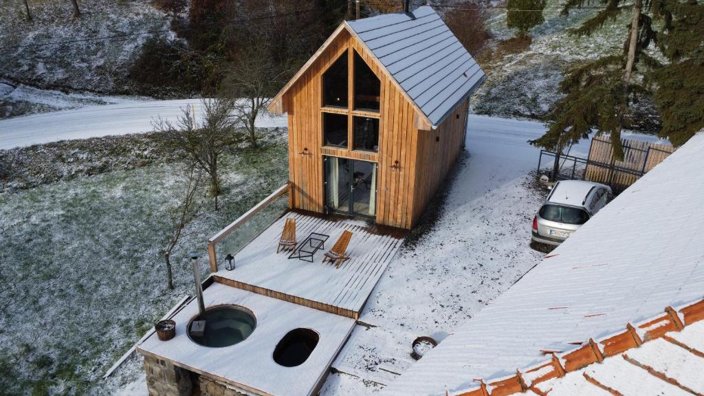 una vista aérea de una pequeña casa de madera en la nieve en Humno, en Nová Baňa