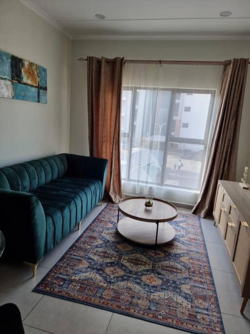 sala de estar con sofá verde y mesa de centro en Crestline2 at Emeraldskye en Lombardy East