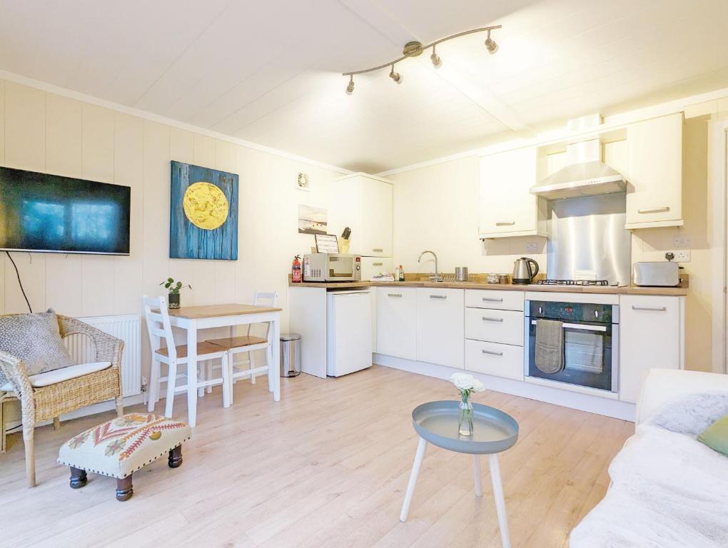 a kitchen and living room with a couch and a table at Elm Lodge in Bosham