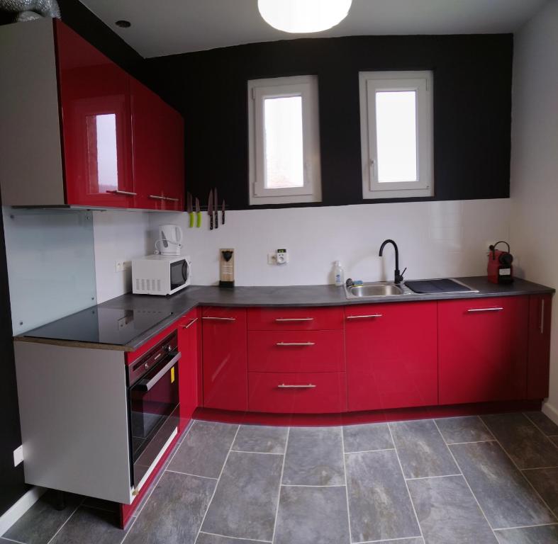 a kitchen with red cabinets and a sink at Tourmalet in Campan