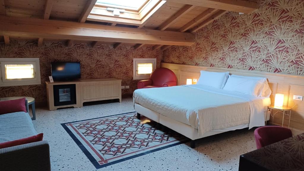 a bedroom with a bed and two chairs and a television at B&B Opera Prima in Verona