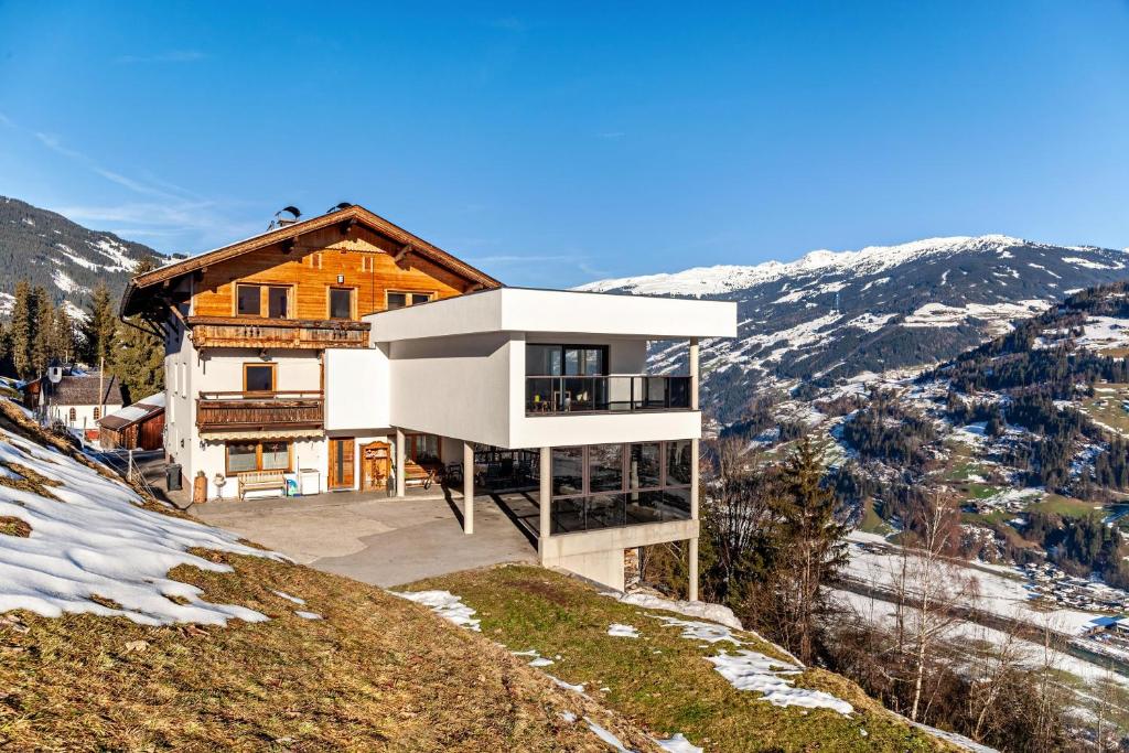 une maison au sommet d'une colline avec de la neige dans l'établissement Fewo Innerspielleiten 20 Personen, à Hippach