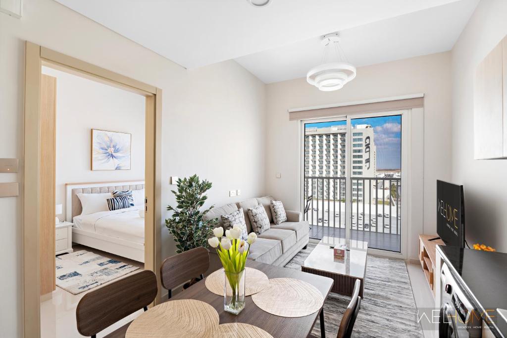 een woonkamer met een bank en een tafel bij WelHome - Breathtaking View 1BR Apt in Damac Hills 2 in Dubai