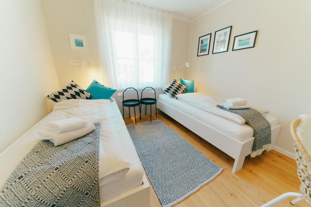 - un salon avec deux lits blancs et une fenêtre dans l'établissement seehaus ausZEIT, à Faak am See