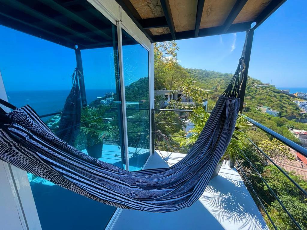 a hammock in a house with a view of the ocean at Tamarindo Beach hostel in Taganga