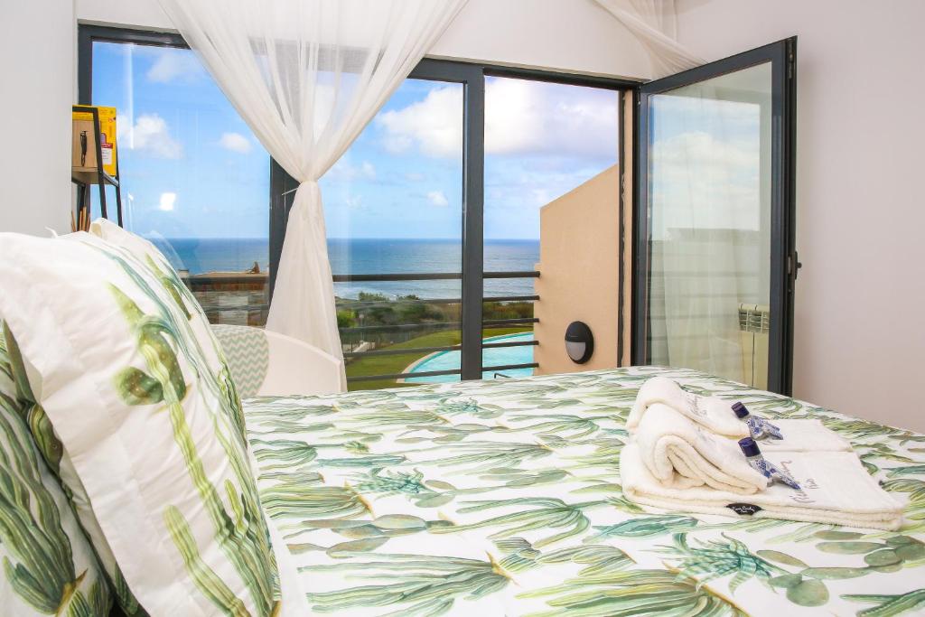 a bedroom with a bed with a view of the ocean at Casa Menezes in Lourinhã