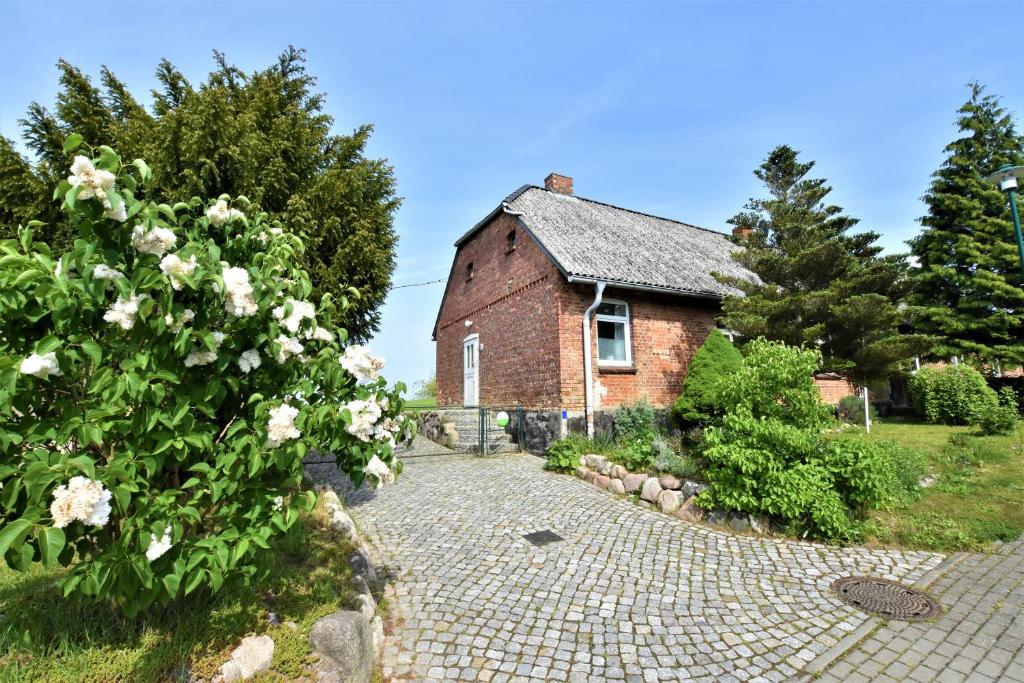 an old brick house with a garden and flowers at "Haus Seegang" für Naturliebhaber, strandnah, ruhig, mit großem Garten in Pepelow