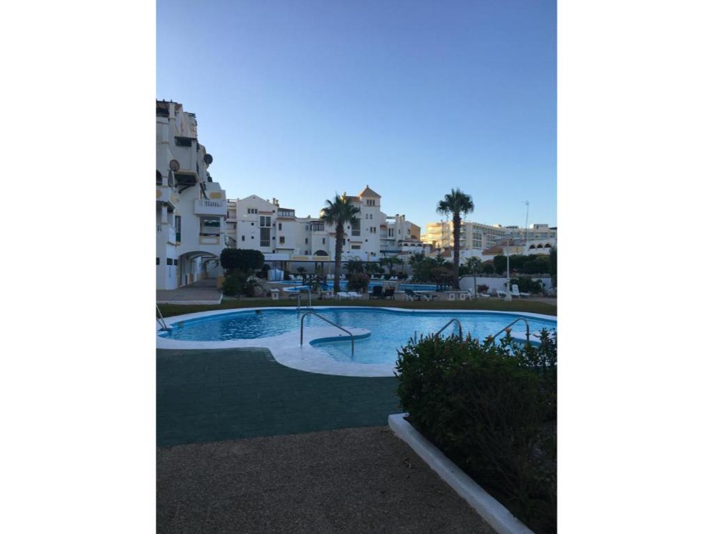 a swimming pool with buildings in the background at Roquemar dreams 613 in Roquetas de Mar
